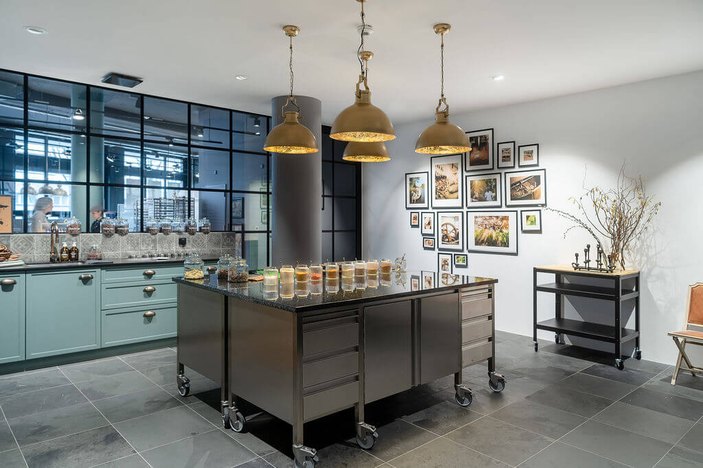 Private chocolatier leading a chocolate bar making workshop in a professional atelier in Switzerland