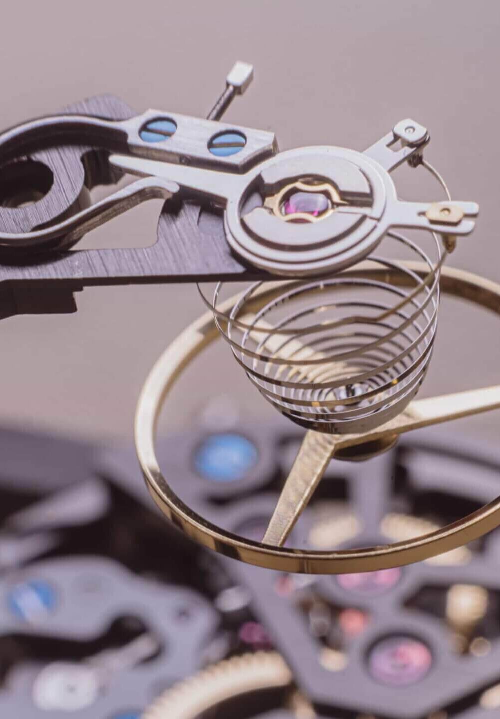 Close-up of a Swiss watchmaker using a precision tool to place a component on a luxury mechanical watch movement