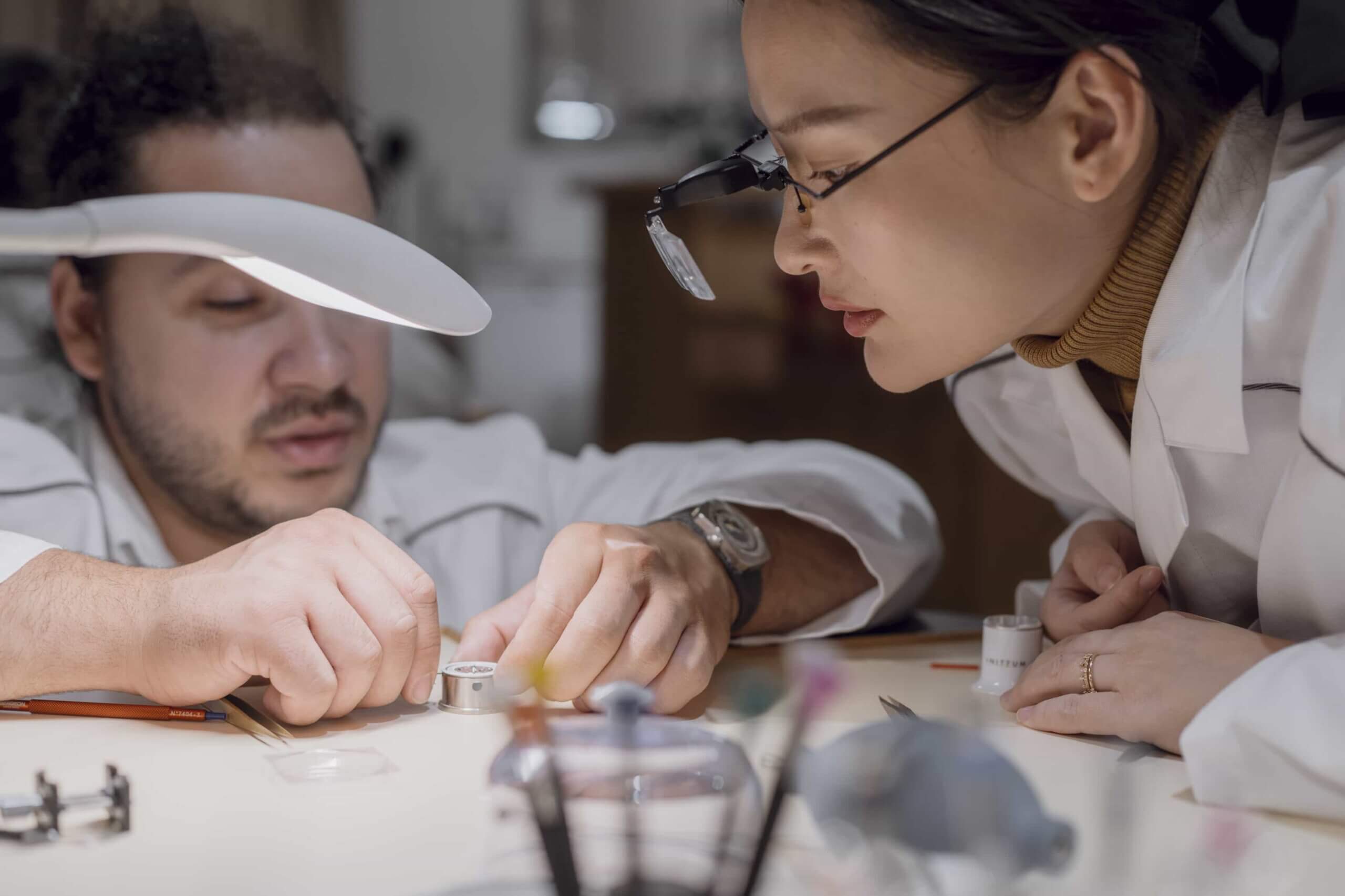 Swiss master watchmaker closely examining a customer’s luxury watch during a precision assembly process